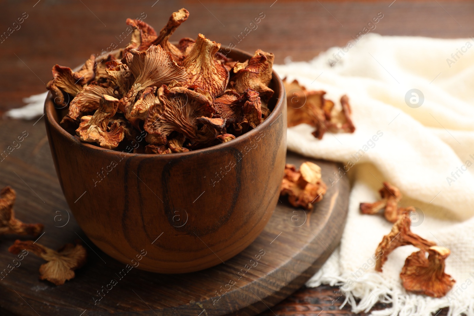 Photo of Dried chanterelle mushrooms on wooden table, closeup