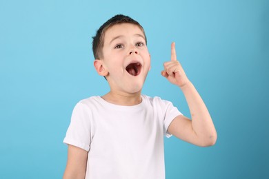 Photo of Portrait of surprised boy on light blue background