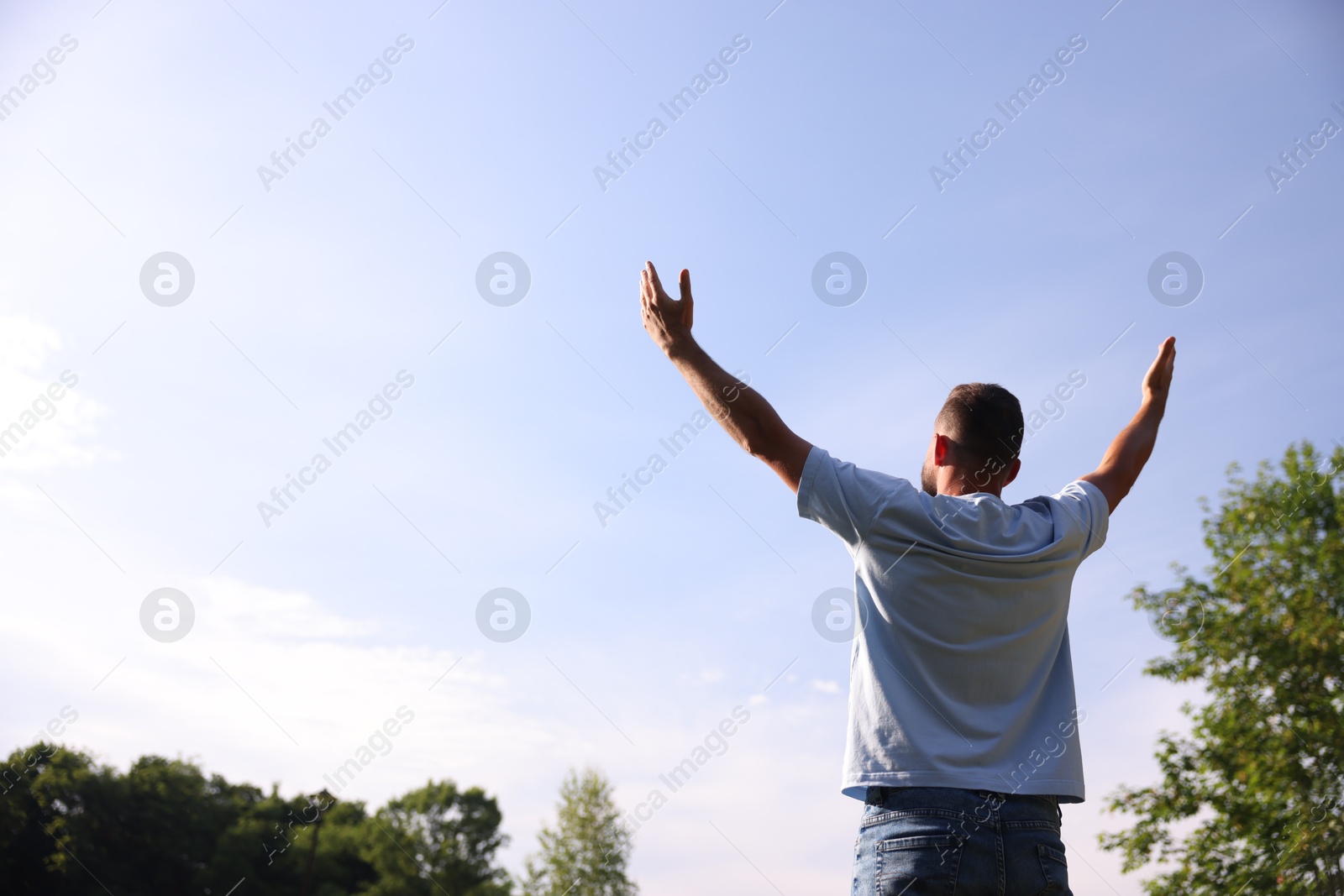 Feeling freedom. Man enjoying time outdoors, back view. Space for text Photo of Feeling freedom. Man enjoying time outdoors, back view. Space for text