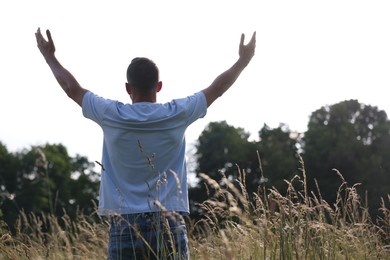 Photo of Feeling freedom. Man enjoying time outdoors, back view. Space for text