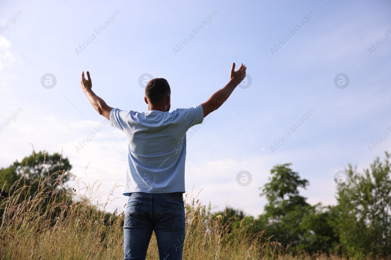 Feeling freedom. Man enjoying time outdoors, back view. Space for text Photo of Feeling freedom. Man enjoying time outdoors, back view. Space for text