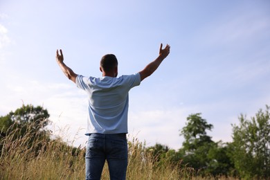 Photo of Feeling freedom. Man enjoying time outdoors, back view. Space for text