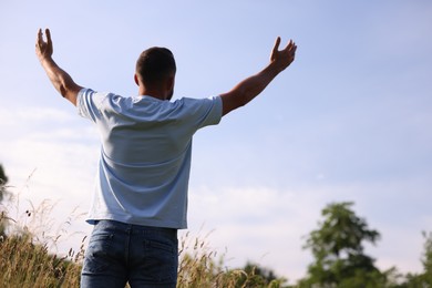 Photo of Feeling freedom. Man enjoying time outdoors, back view. Space for text