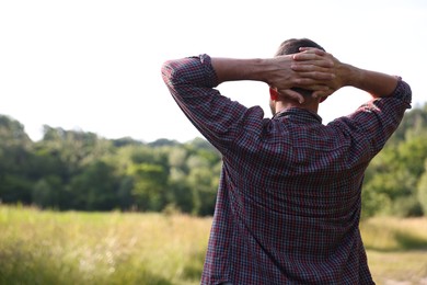 Photo of Feeling freedom. Man enjoying time outdoors, back view. Space for text