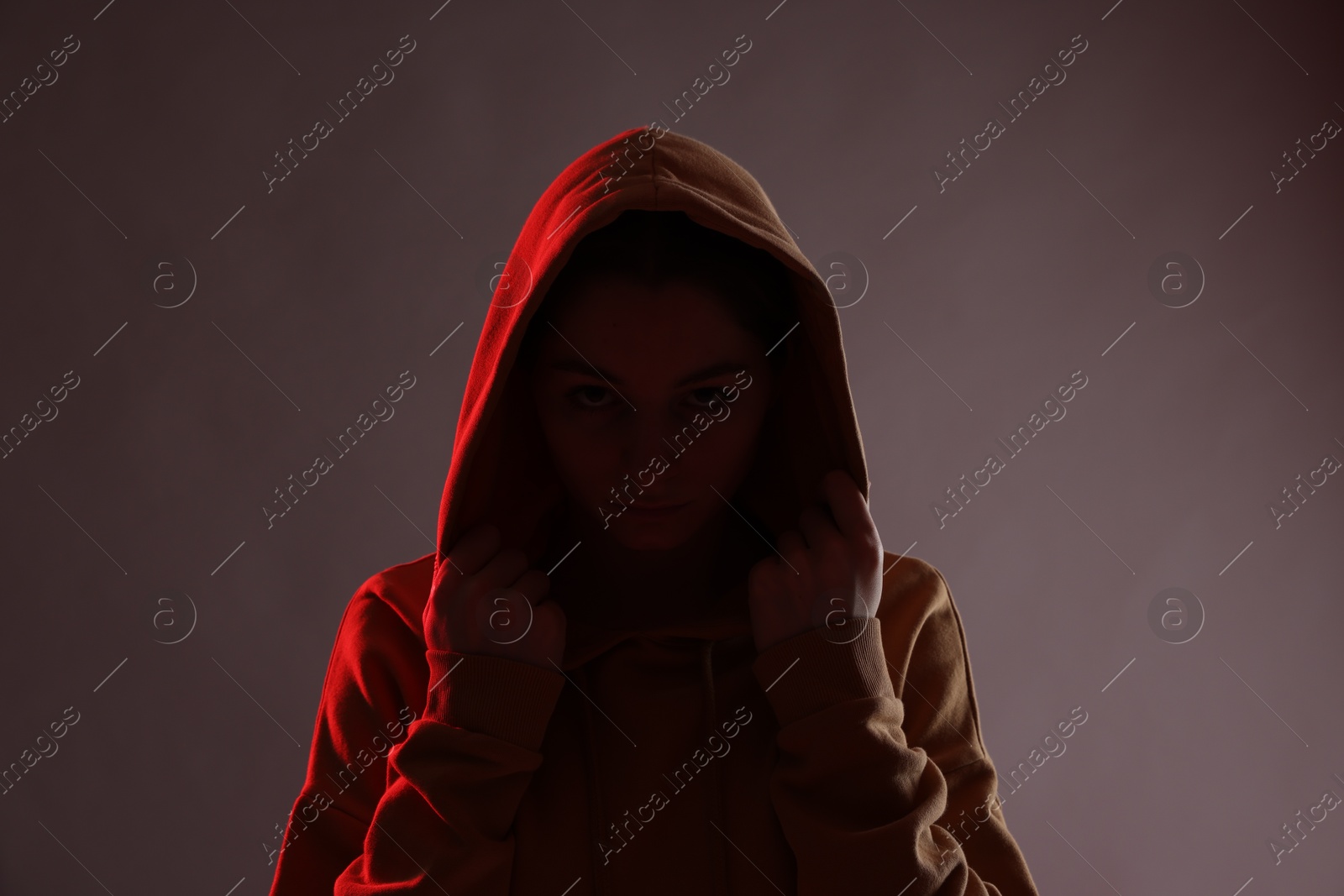 Anonymity. Woman hiding her face on dark background Photo of Anonymity. Woman hiding her face on dark background