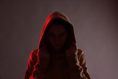 Photo of Anonymity. Woman hiding her face on dark background