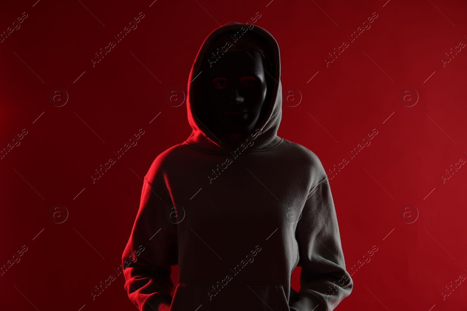 Anonymity. Woman wearing mask on red background Photo of Anonymity. Woman wearing mask on red background
