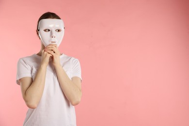 Photo of Anonymity. Woman wearing mask on pink background, space for text