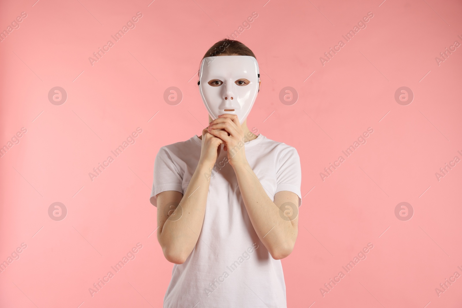 Anonymity. Woman wearing mask on pink background Photo of Anonymity. Woman wearing mask on pink background