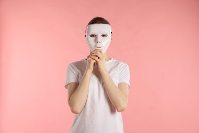 Photo of Anonymity. Woman wearing mask on pink background