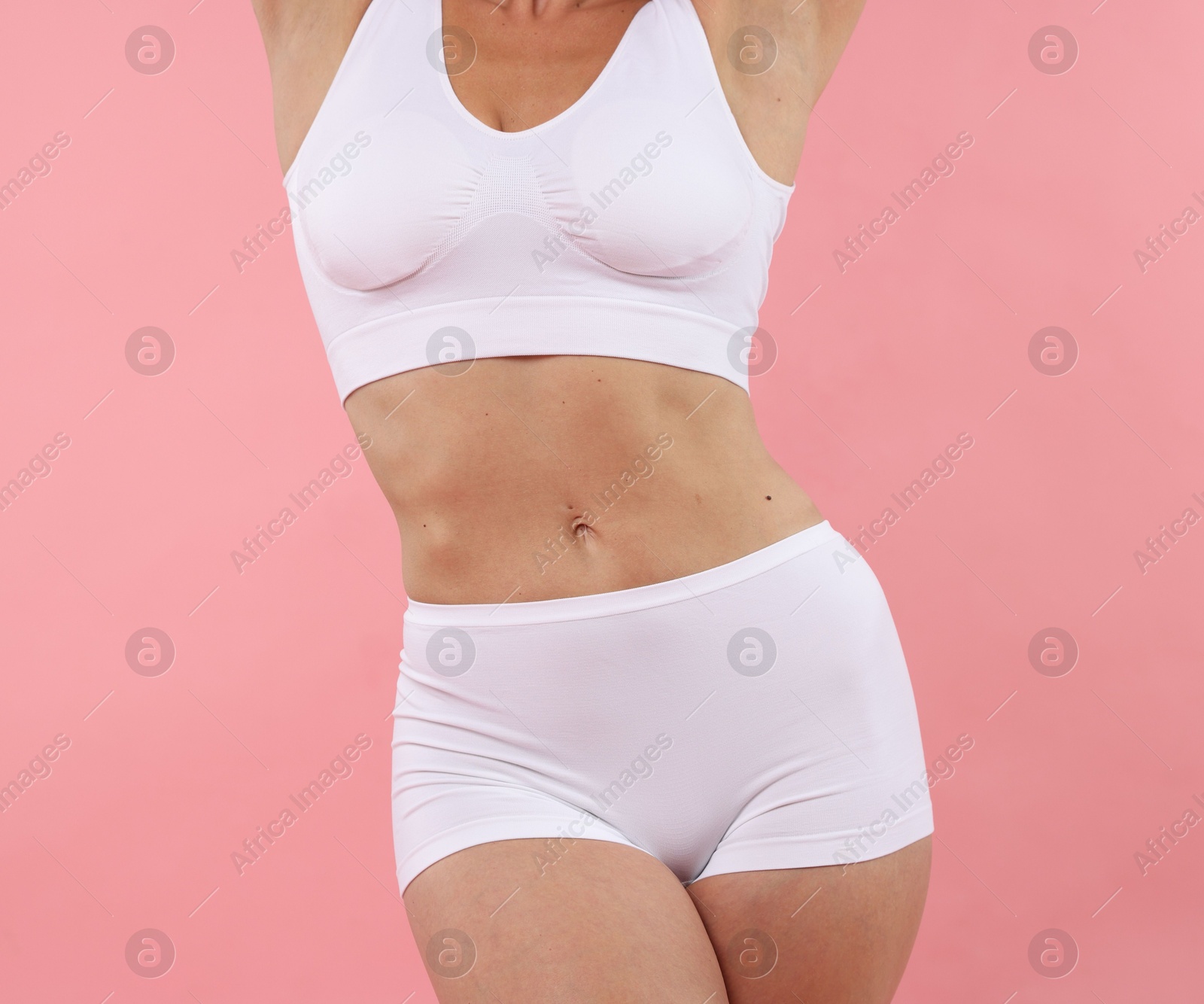 Fit woman with perfect body on pink background, closeup Photo of Fit woman with perfect body on pink background, closeup