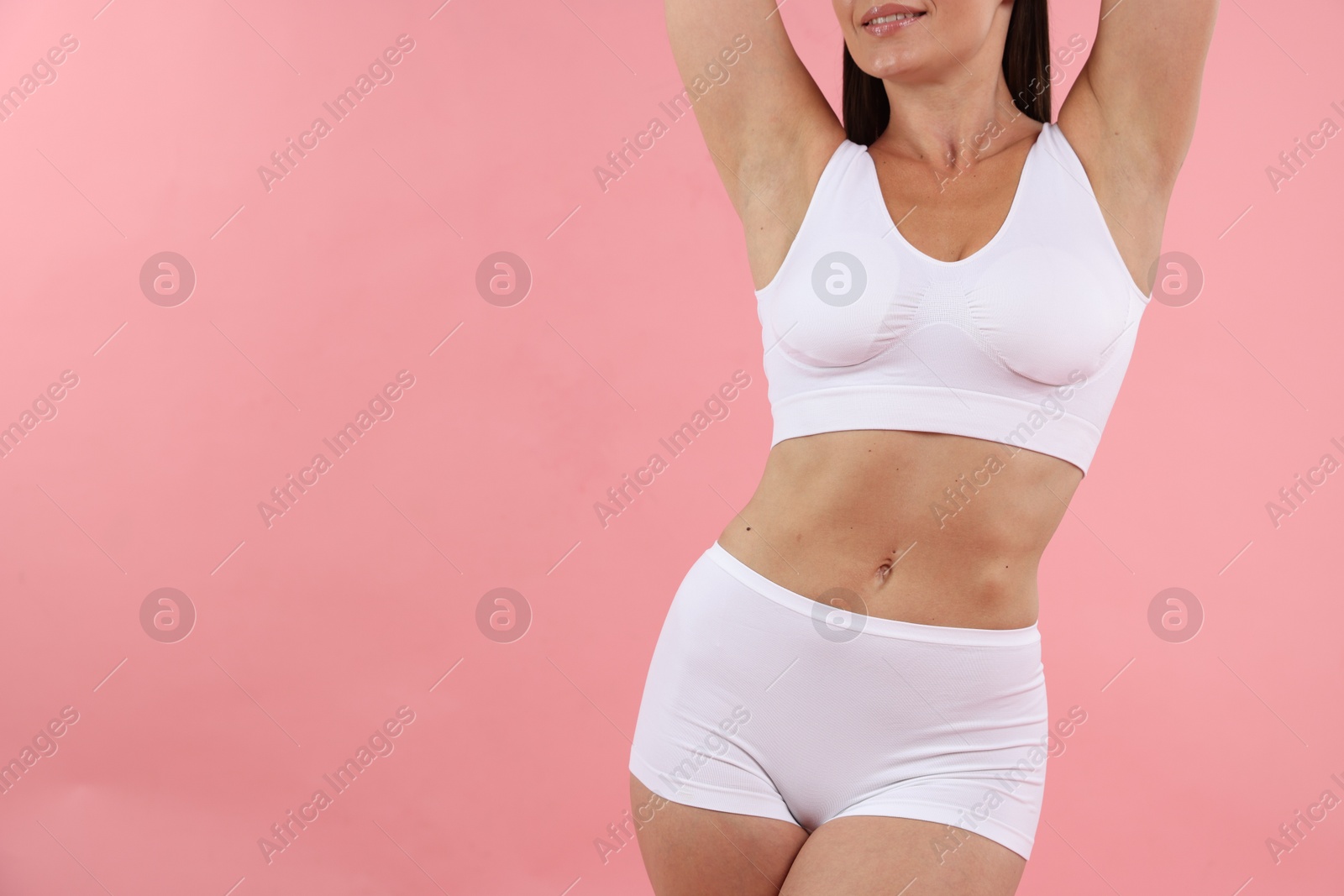 Fit woman with perfect body on pink background, closeup. Space for text Photo of Fit woman with perfect body on pink background, closeup. Space for text