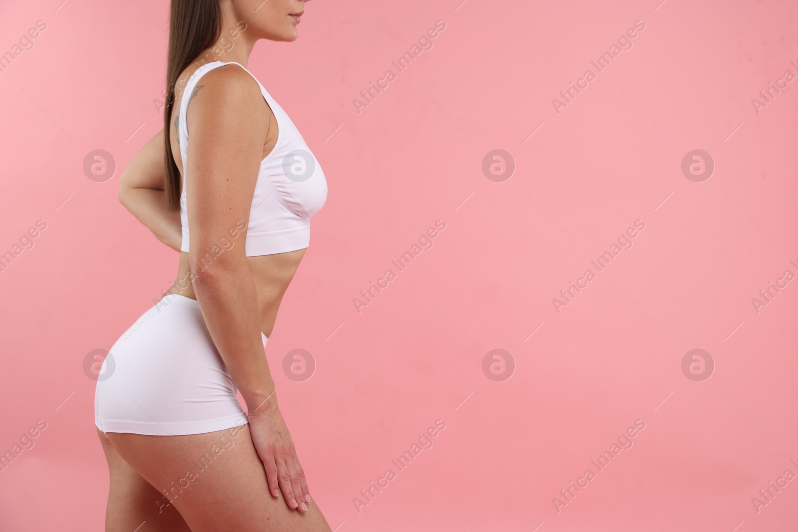 Photo of Fit woman with perfect body on pink background, closeup. Space for text