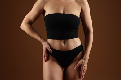 Photo of Fit woman with perfect body on brown background, closeup