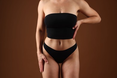 Photo of Fit woman with perfect body on brown background, closeup