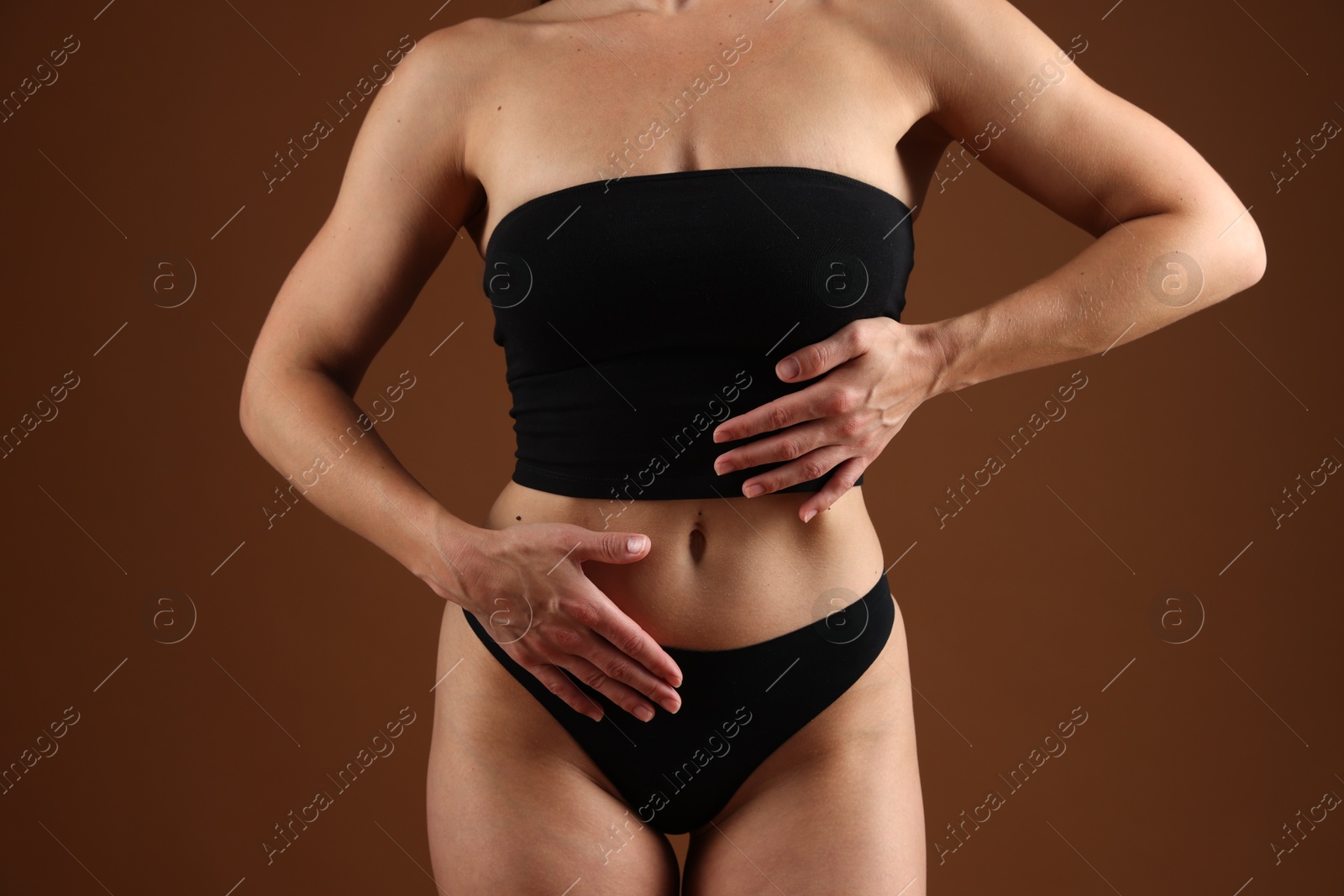 Fit woman with perfect body on brown background, closeup Photo of Fit woman with perfect body on brown background, closeup