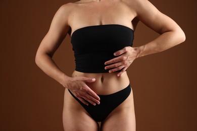 Photo of Fit woman with perfect body on brown background, closeup