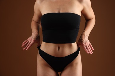 Photo of Fit woman with perfect body on brown background, closeup