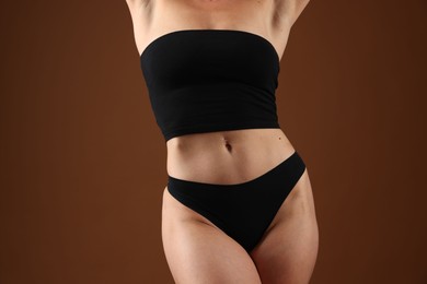 Photo of Fit woman with perfect body on brown background, closeup