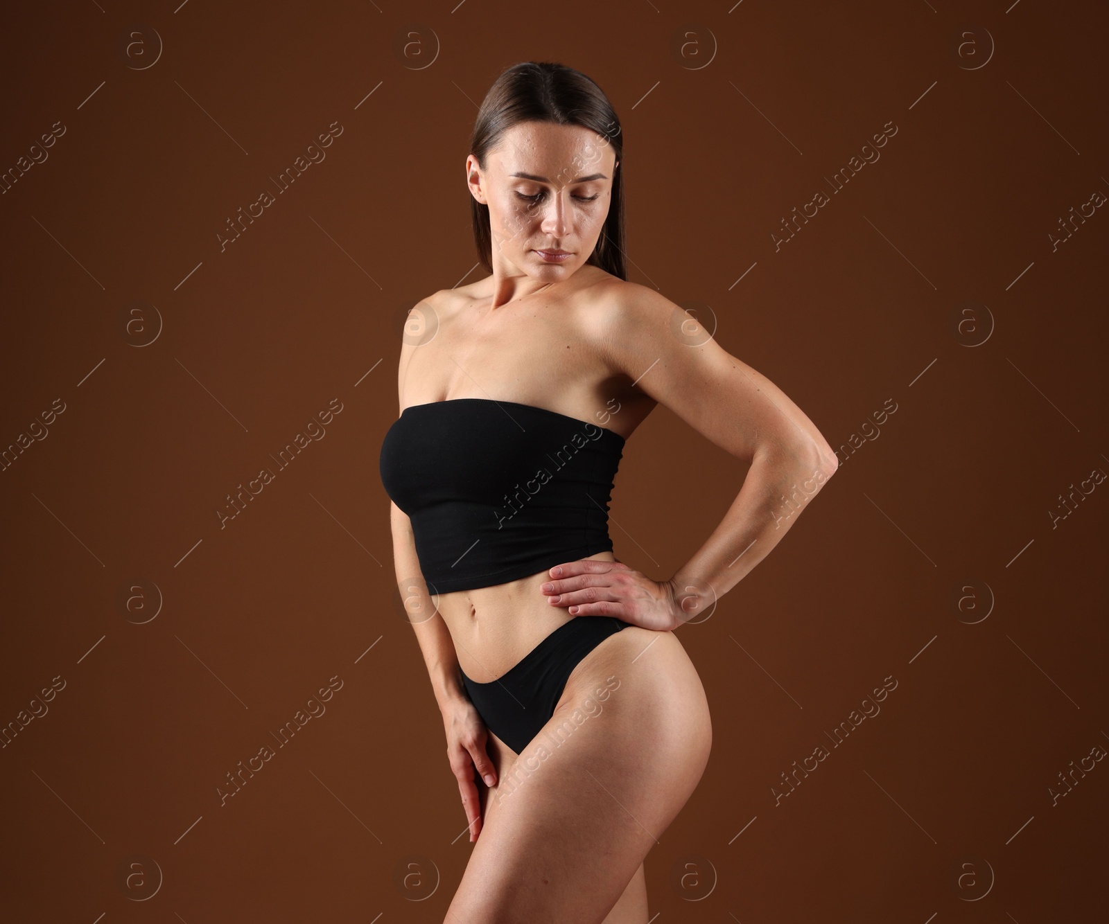 Fit woman with perfect body on brown background Photo of Fit woman with perfect body on brown background