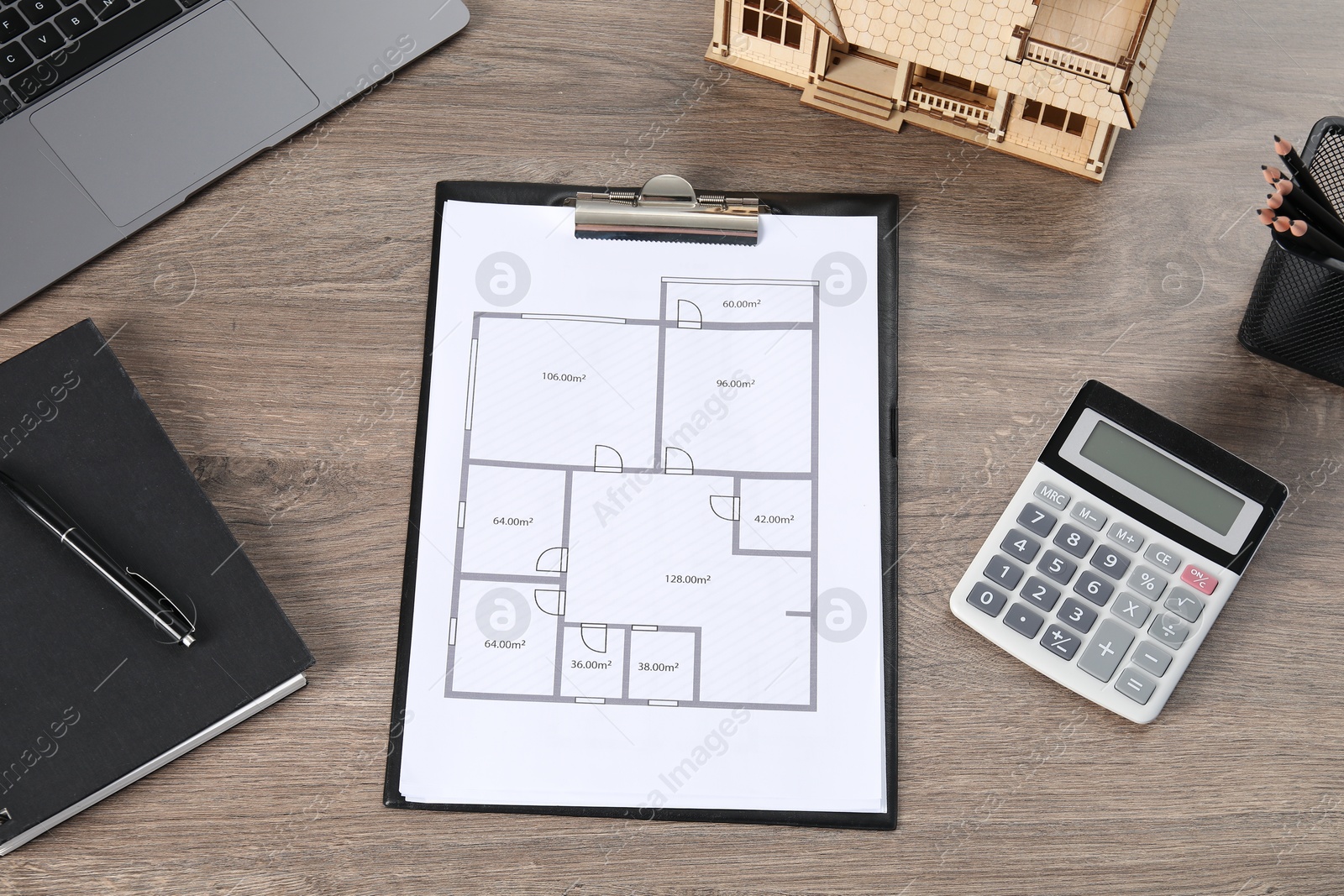 Real estate. House model, floor plan, laptop and calculator on wooden table, above view Photo of Real estate. House model, floor plan, laptop and calculator on wooden table, above view