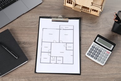 Photo of Real estate. House model, floor plan, laptop and calculator on wooden table, above view