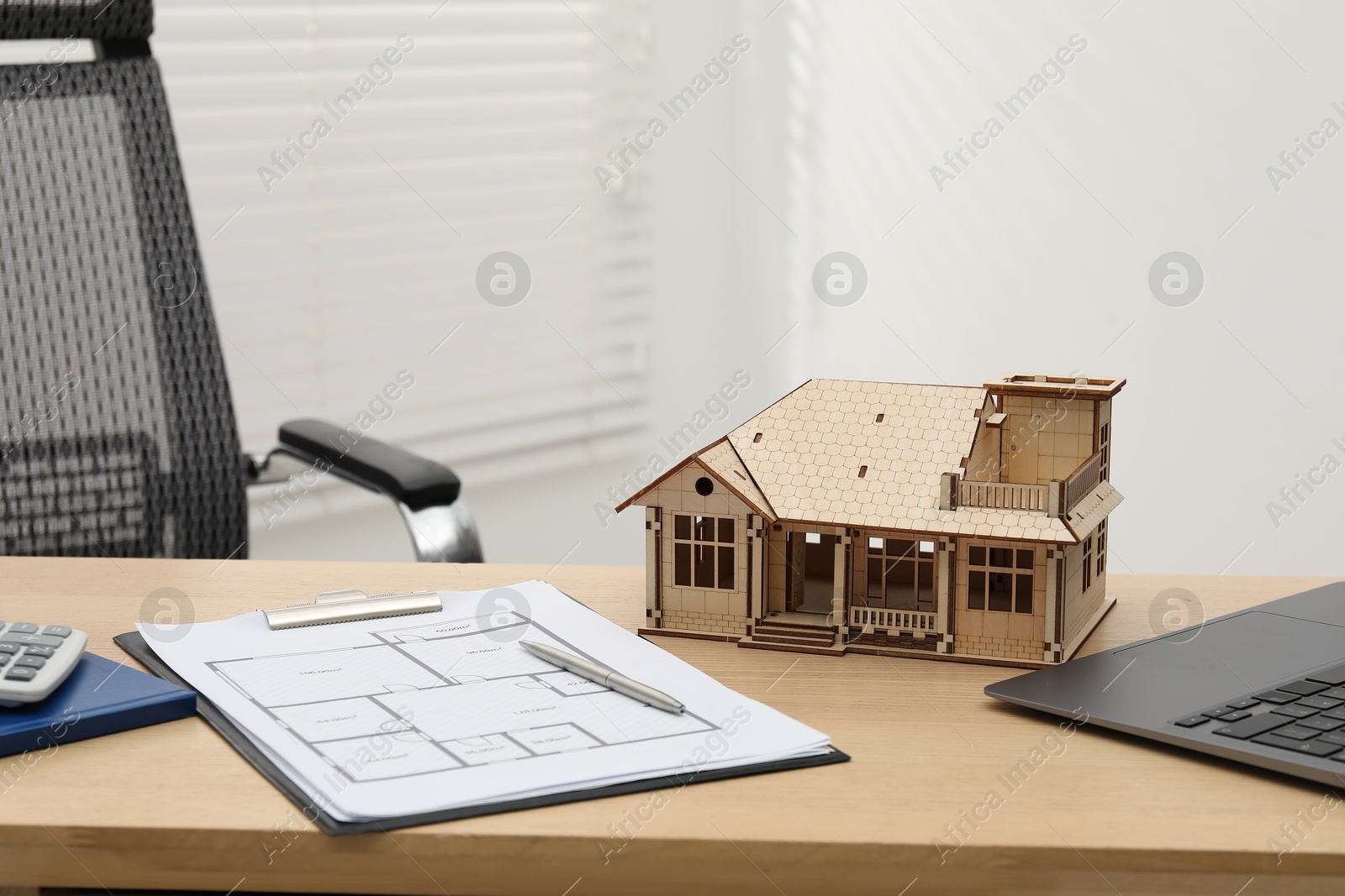 Real estate. House model, floor plan and laptop on wooden table indoors Photo of Real estate. House model, floor plan and laptop on wooden table indoors
