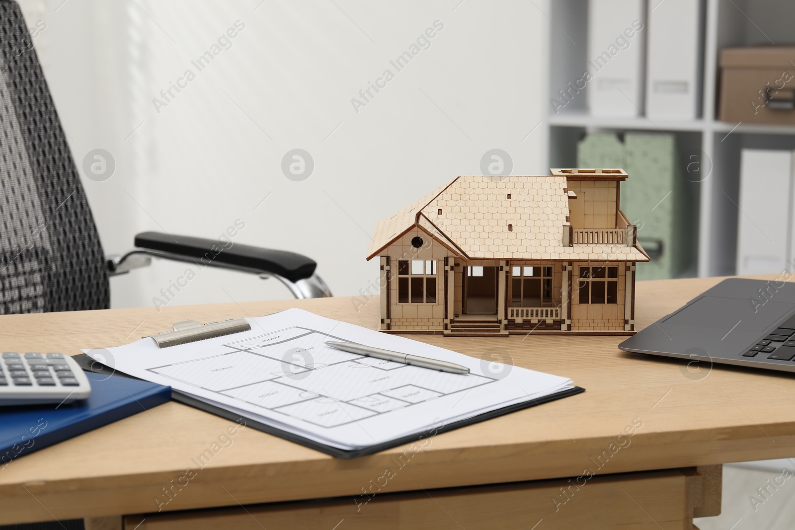 Real estate. House model, floor plan and laptop on wooden table indoors Photo of Real estate. House model, floor plan and laptop on wooden table indoors