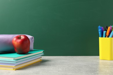 Photo of Stylish stationery and red apple on light desk against chalkboard. space for text