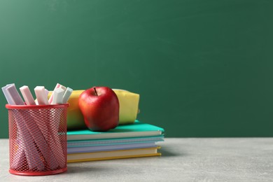 Photo of Stylish stationery and red apple on light desk against chalkboard. space for text