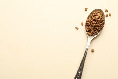 Photo of Spoon with instant coffee on beige background, top view. Space for text