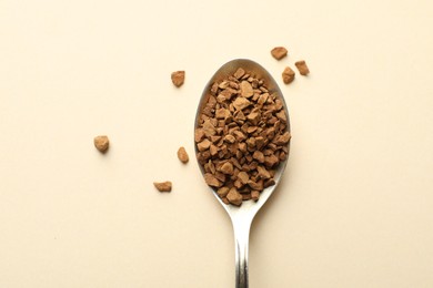 Photo of Spoon with instant coffee on beige background, top view