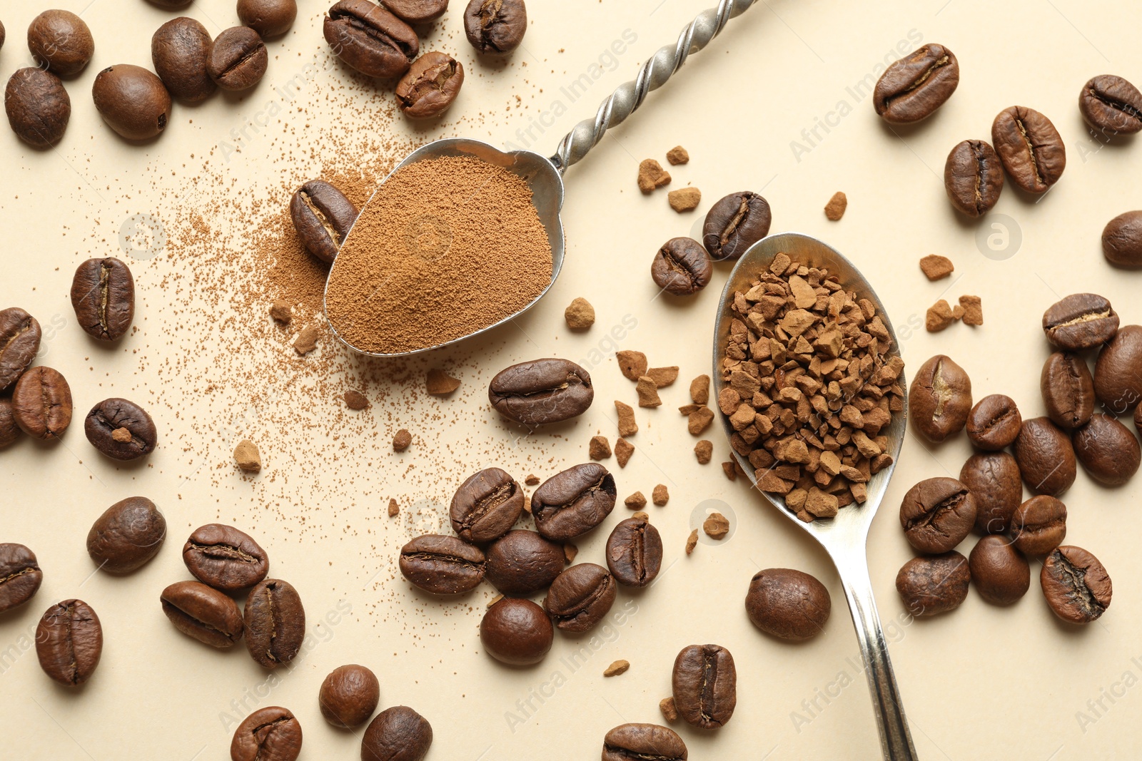 Photo of Spoons with instant coffee and beans on beige background, flat lay