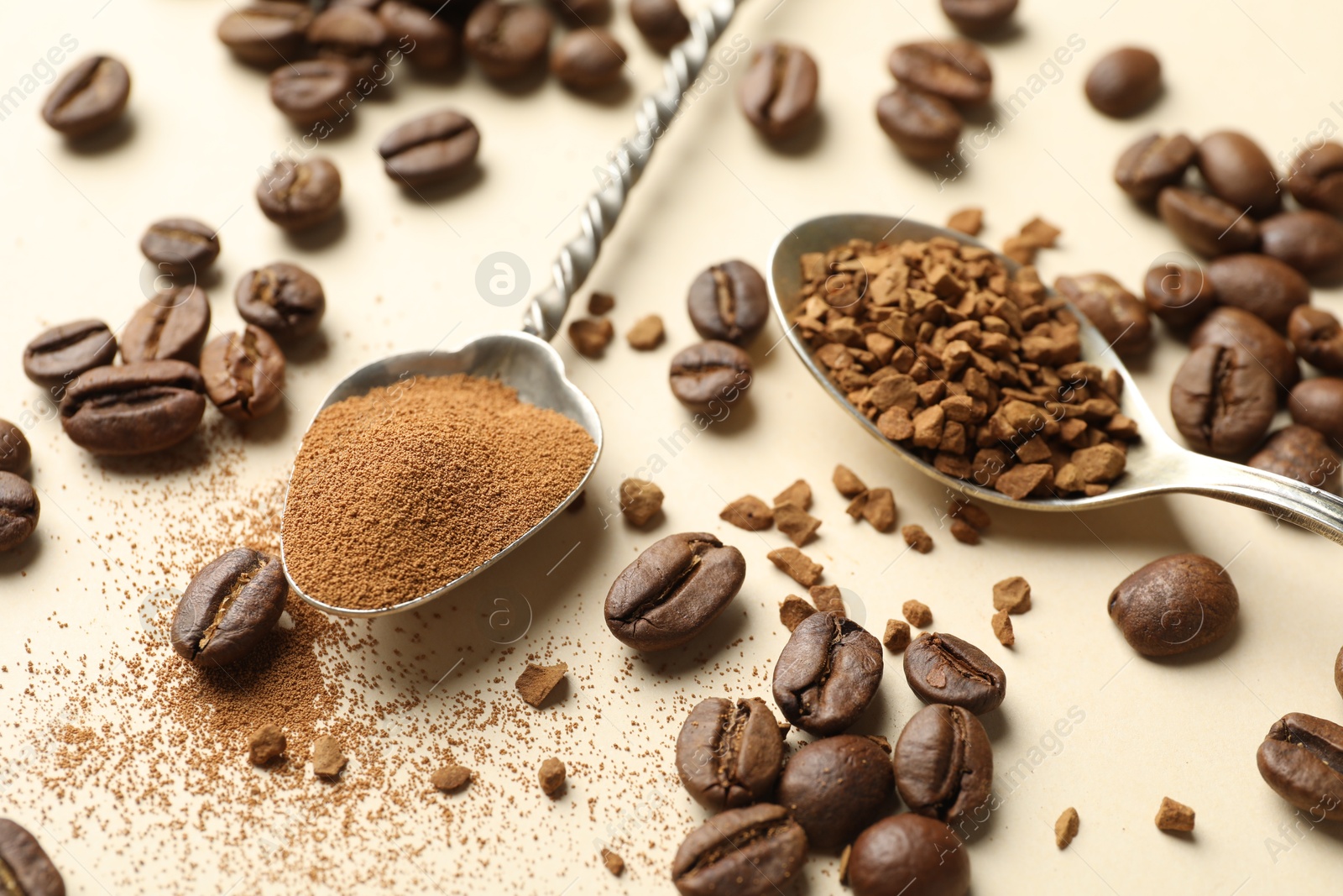 Spoons with instant coffee and beans on beige background, closeup Photo of Spoons with instant coffee and beans on beige background, closeup