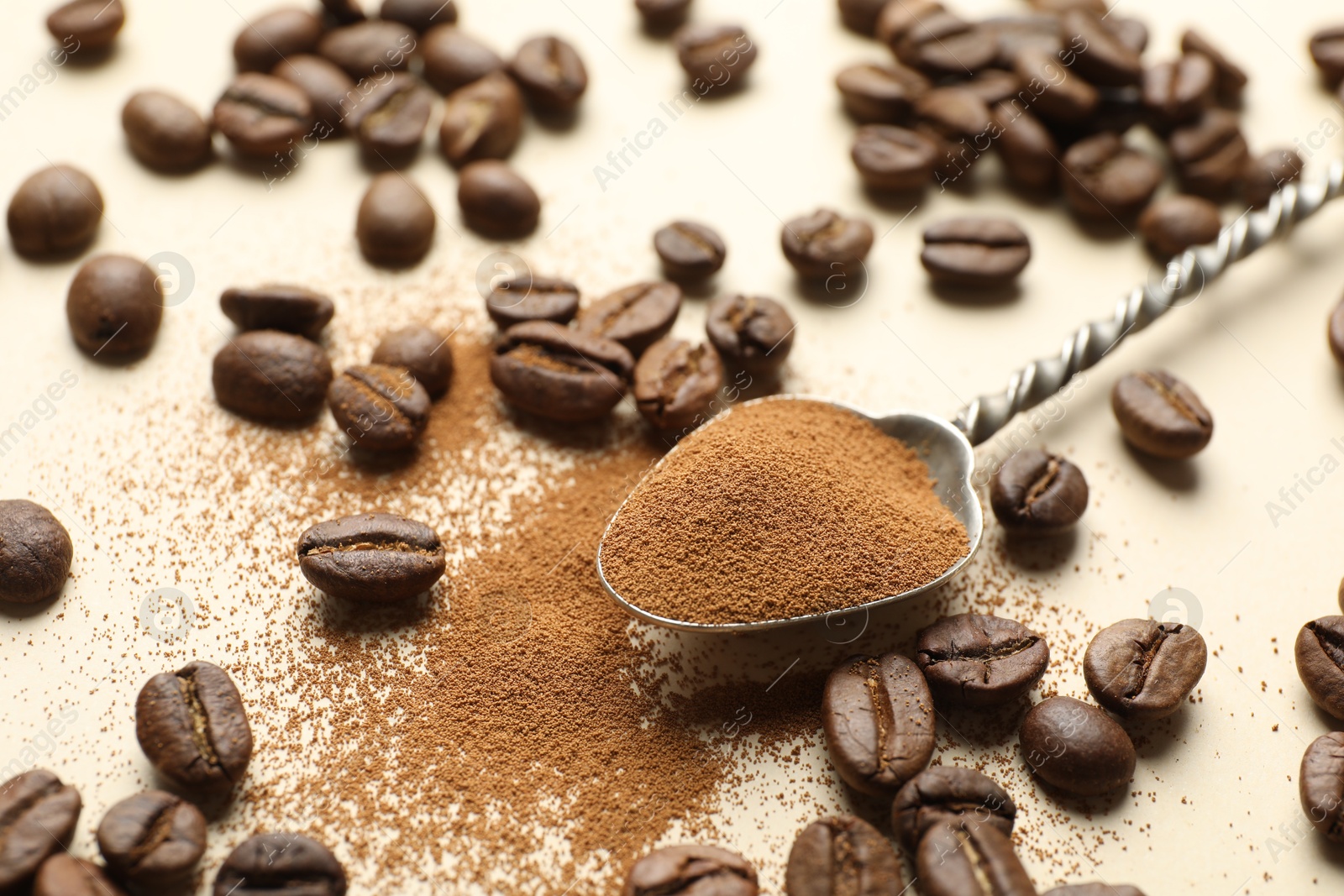 Spoon with instant coffee and beans on beige background, closeup Photo of Spoon with instant coffee and beans on beige background, closeup