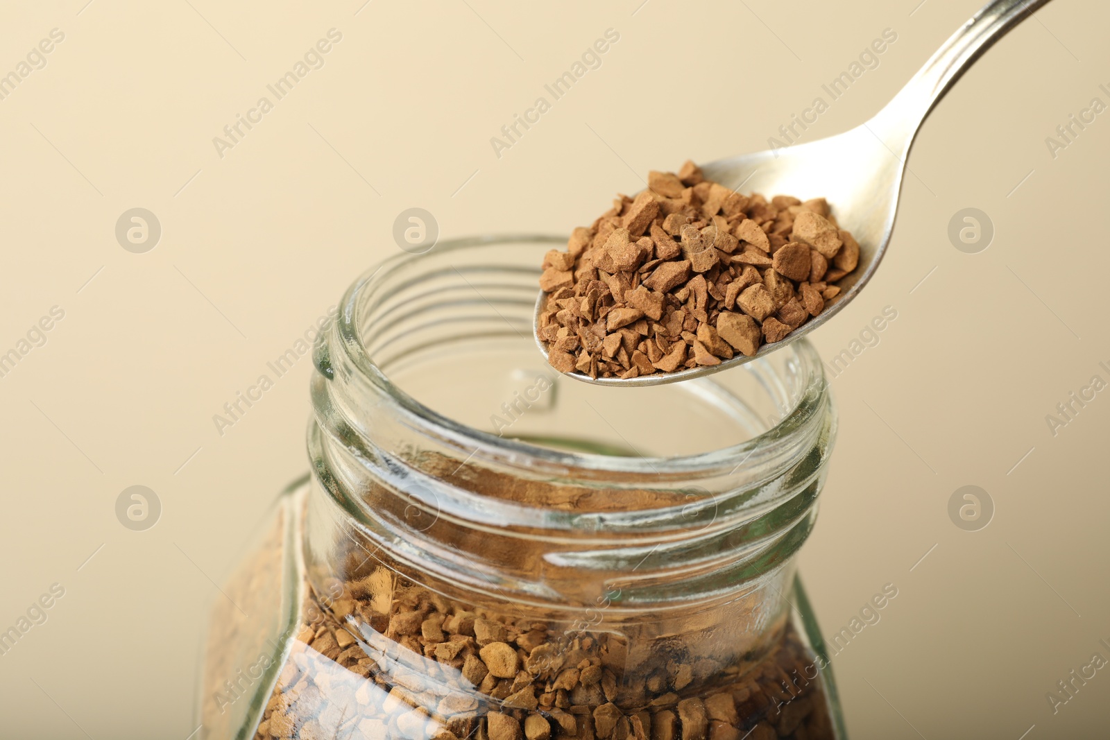 Taking instant coffee with spoon on beige background, closeup Photo of Taking instant coffee with spoon on beige background, closeup