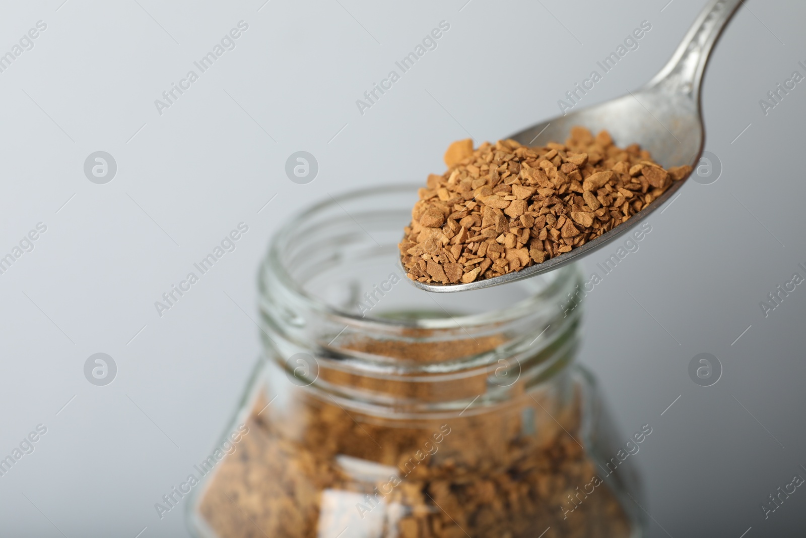 Taking instant coffee with spoon on grey background, closeup Photo of Taking instant coffee with spoon on grey background, closeup