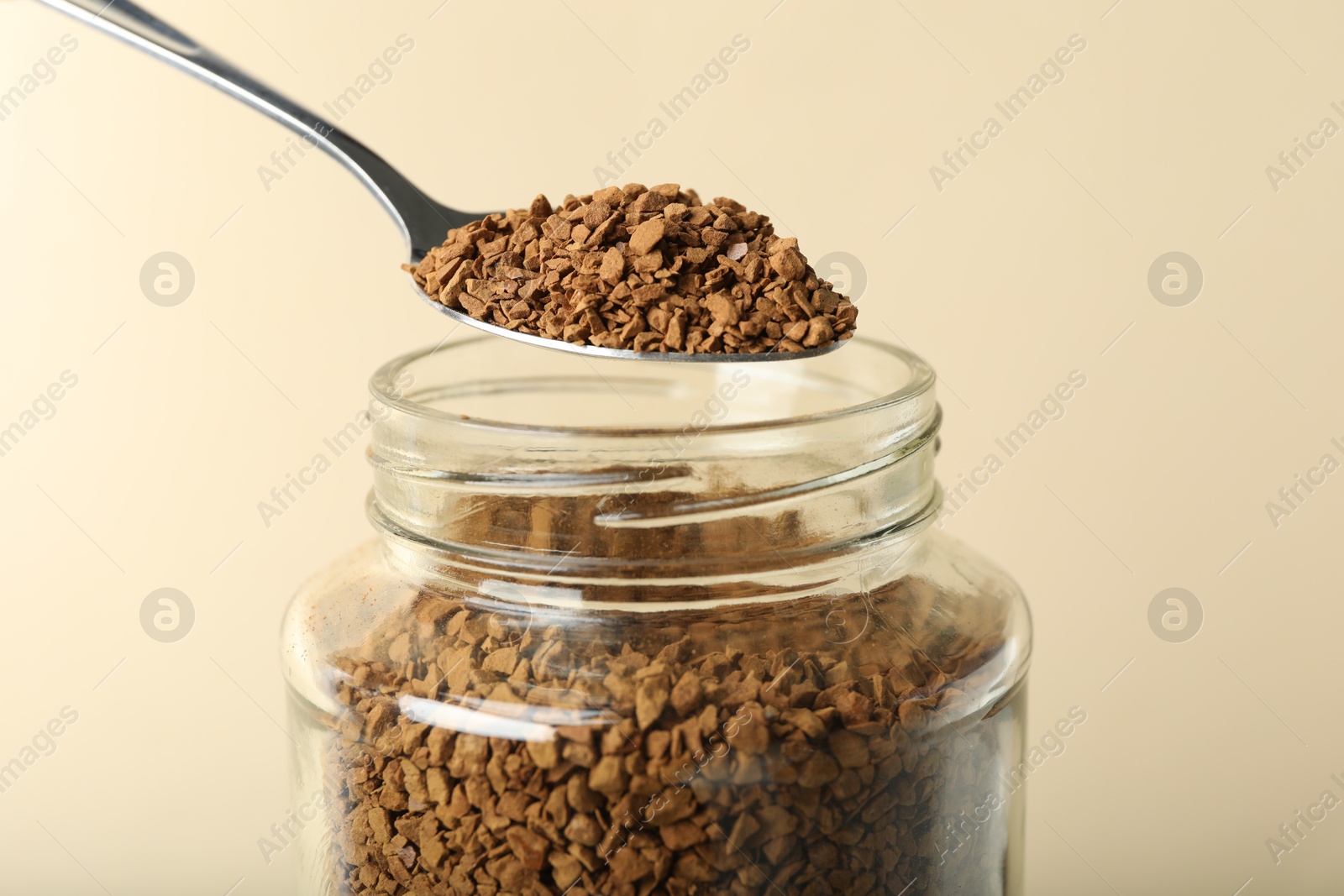 Taking instant coffee with spoon on beige background, closeup Photo of Taking instant coffee with spoon on beige background, closeup