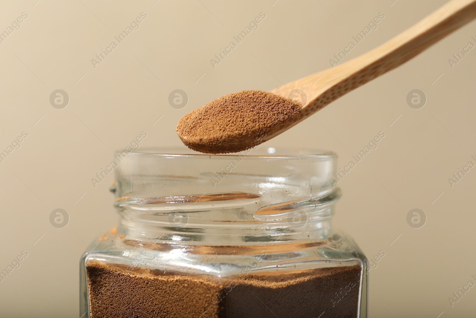 Taking instant coffee with spoon on beige background, closeup Photo of Taking instant coffee with spoon on beige background, closeup