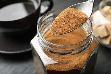 Photo of Taking instant coffee from jar at table, closeup