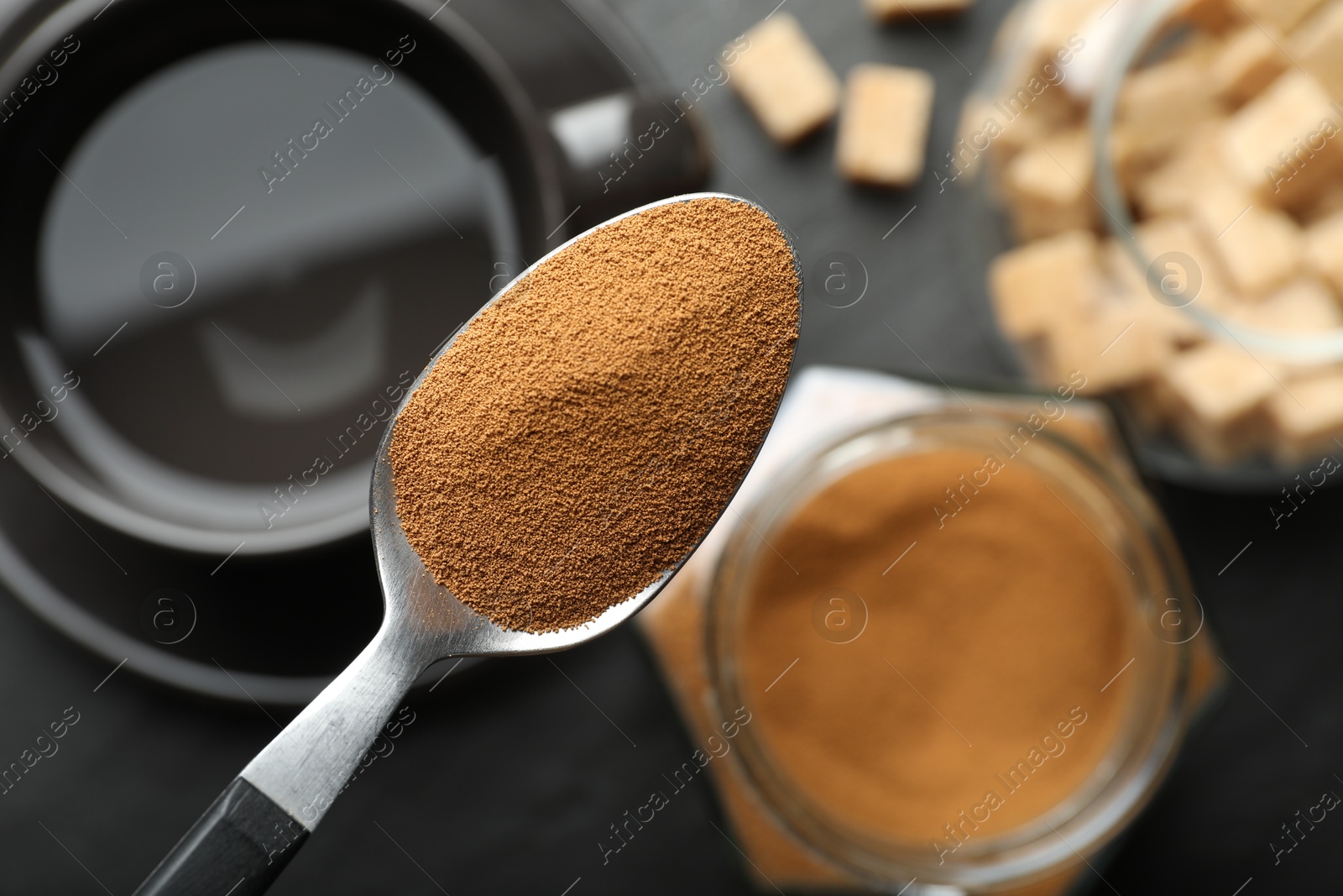 Spoon with instant coffee on blurred background, top view Photo of Spoon with instant coffee on blurred background, top view