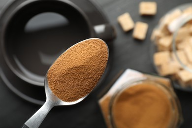 Photo of Spoon with instant coffee on blurred background, top view