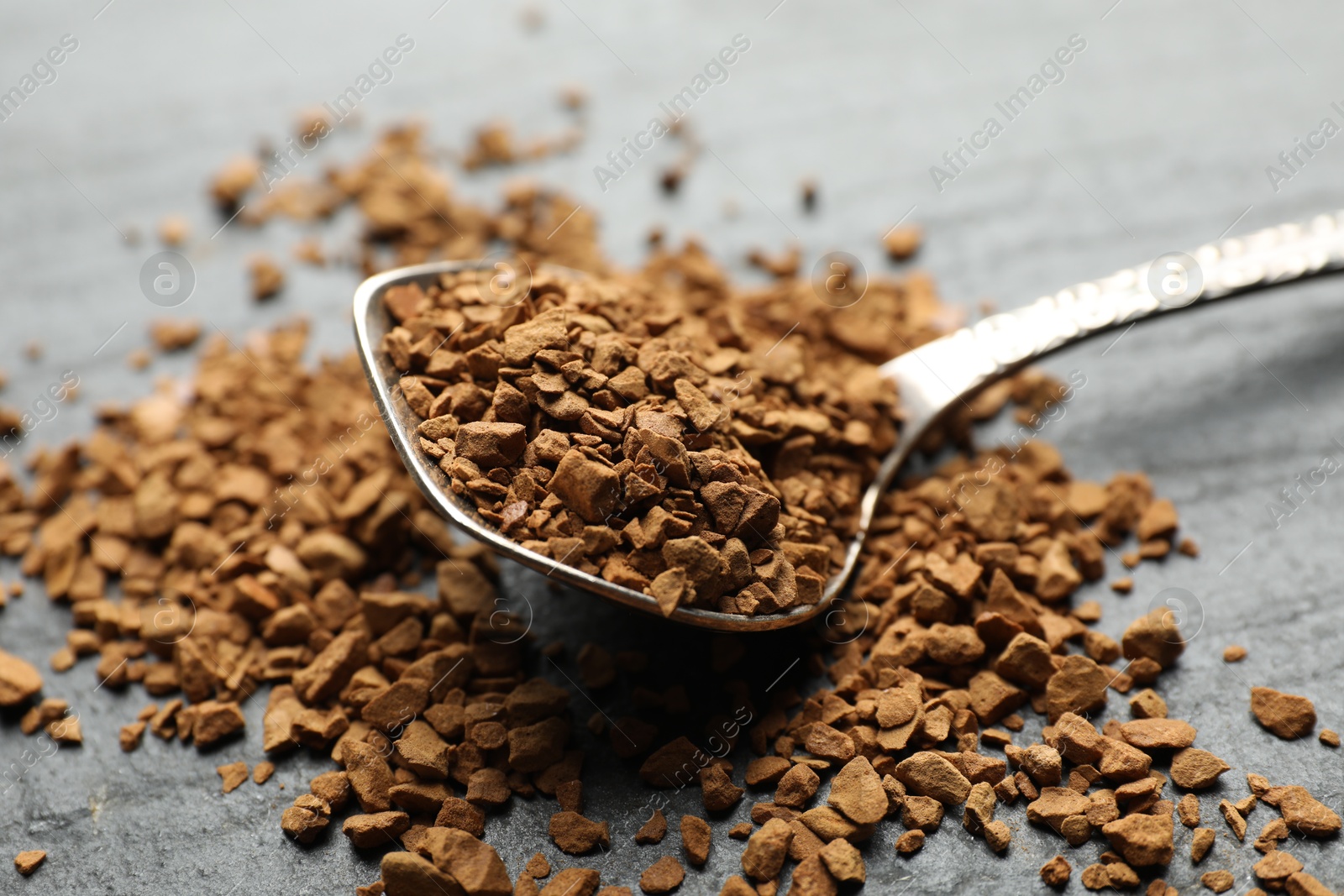 Spoon with instant coffee on black table, closeup Photo of Spoon with instant coffee on black table, closeup