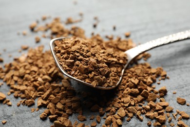 Photo of Spoon with instant coffee on black table, closeup