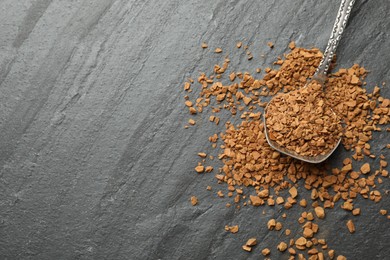 Photo of Spoon with instant coffee on black table, top view. Space for text