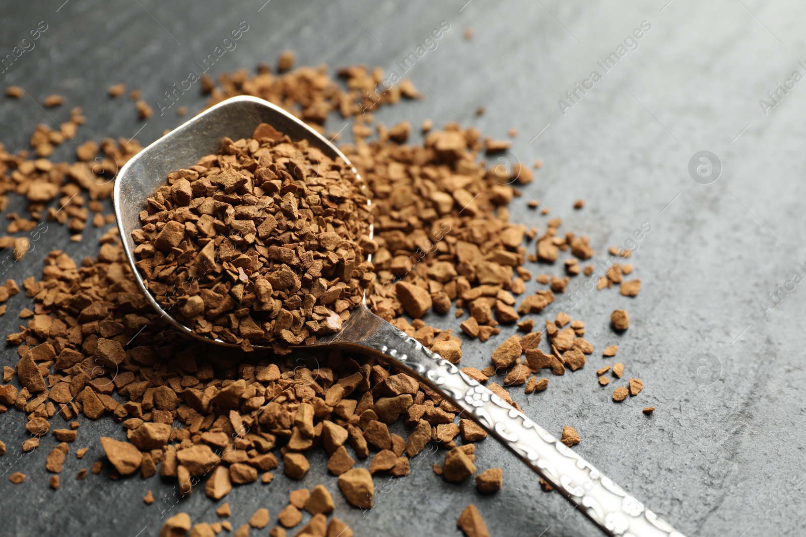 Spoon with instant coffee on black table, closeup. Space for text Photo of Spoon with instant coffee on black table, closeup. Space for text