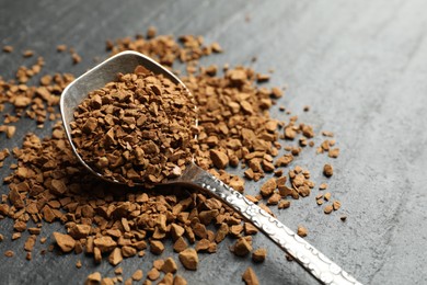 Photo of Spoon with instant coffee on black table, closeup. Space for text