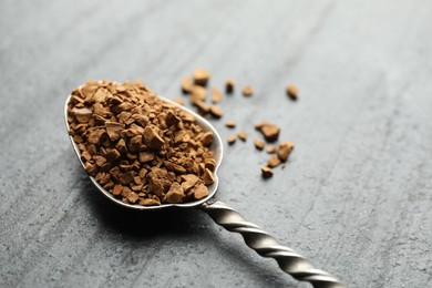 Photo of Spoon with instant coffee on black table, closeup. Space for text