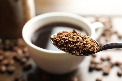 Photo of Spoon with instant coffee on blurred background, closeup