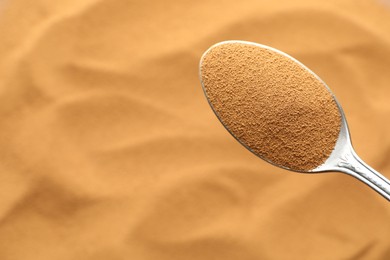 Photo of Spoon with aromatic instant coffee as background, closeup
